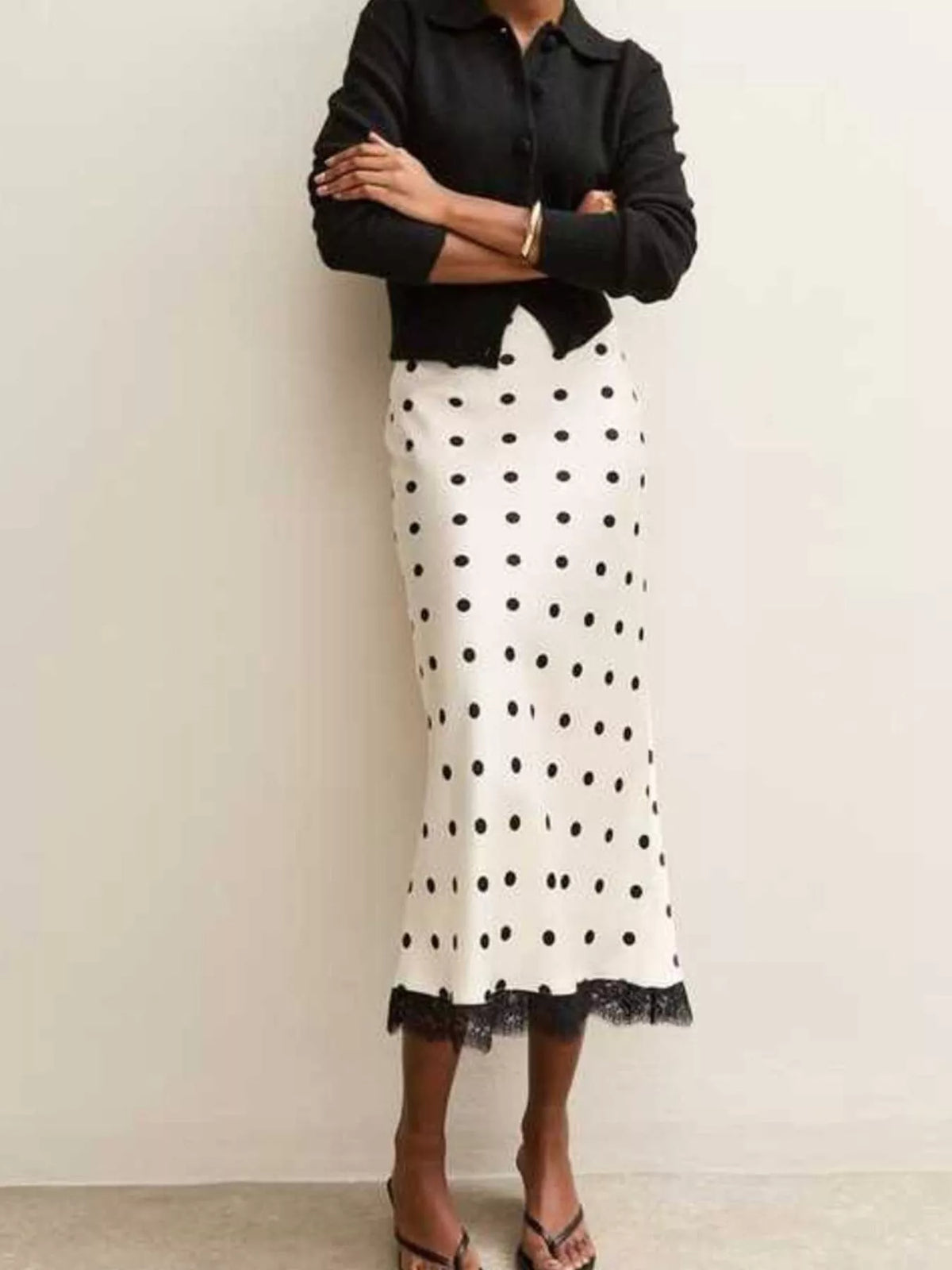 White midi skirt with black polka dots and lace trim at the hem