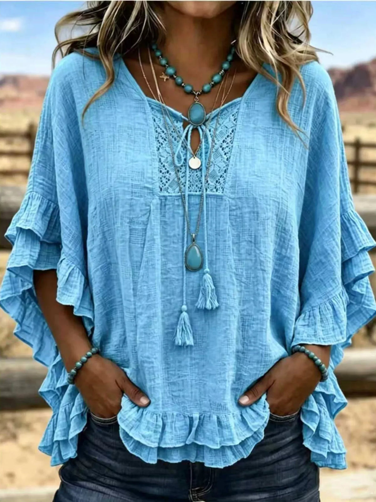 Sky blue tie-neck polyester blouse with ruffled hem and lace yoke detail