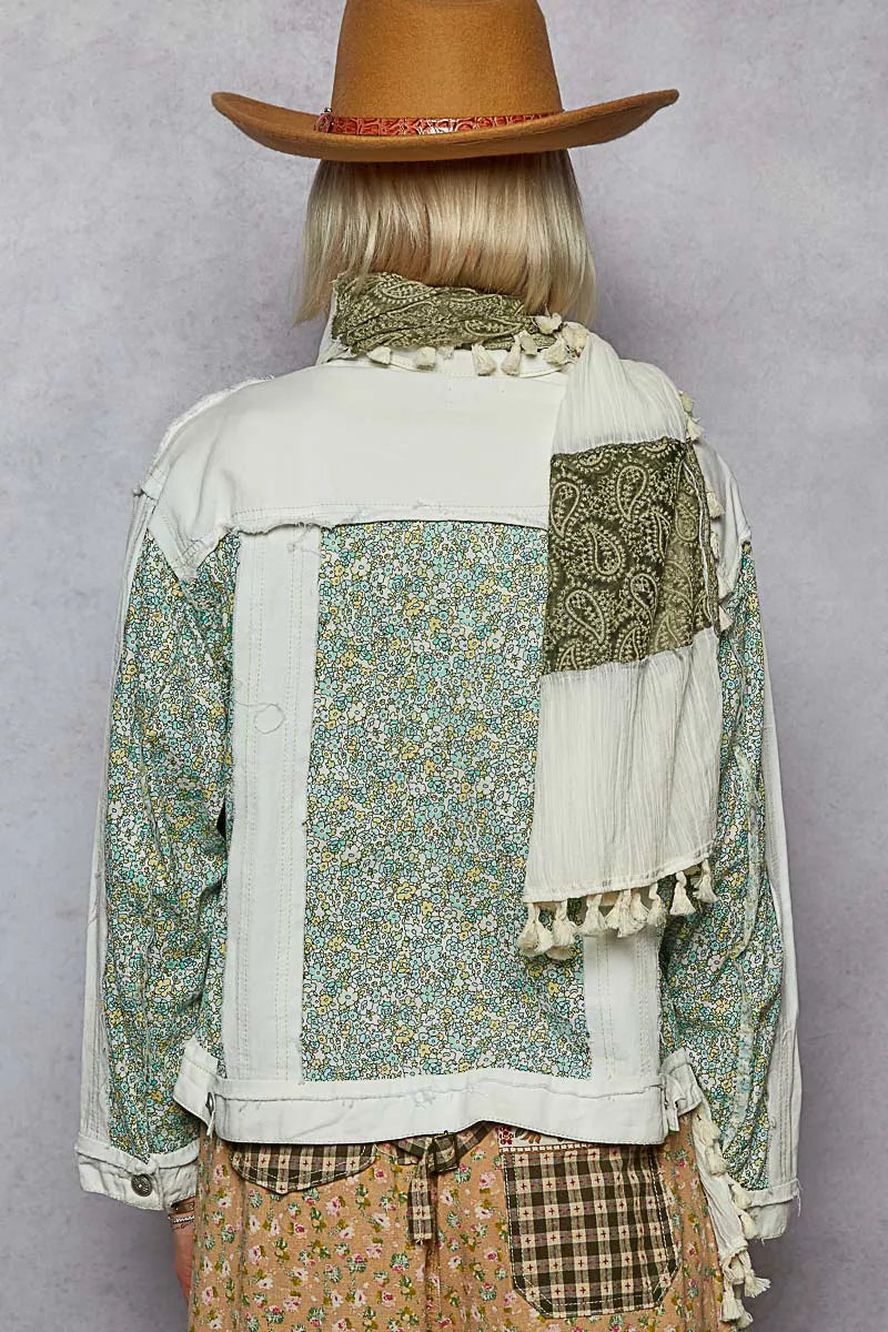Off-white patchwork denim jacket back with green floral panel, fringed cuffs, button closure