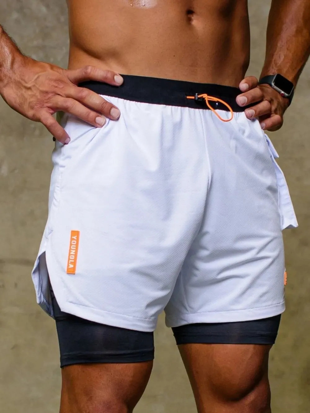 White drawstring shorts with black waistband, orange logo tag, and side pockets