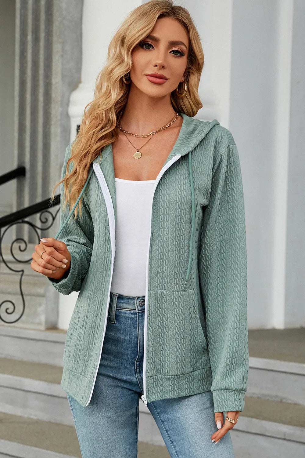 Light green zip-up hoodie with drawstring hood, long sleeves, and front pockets