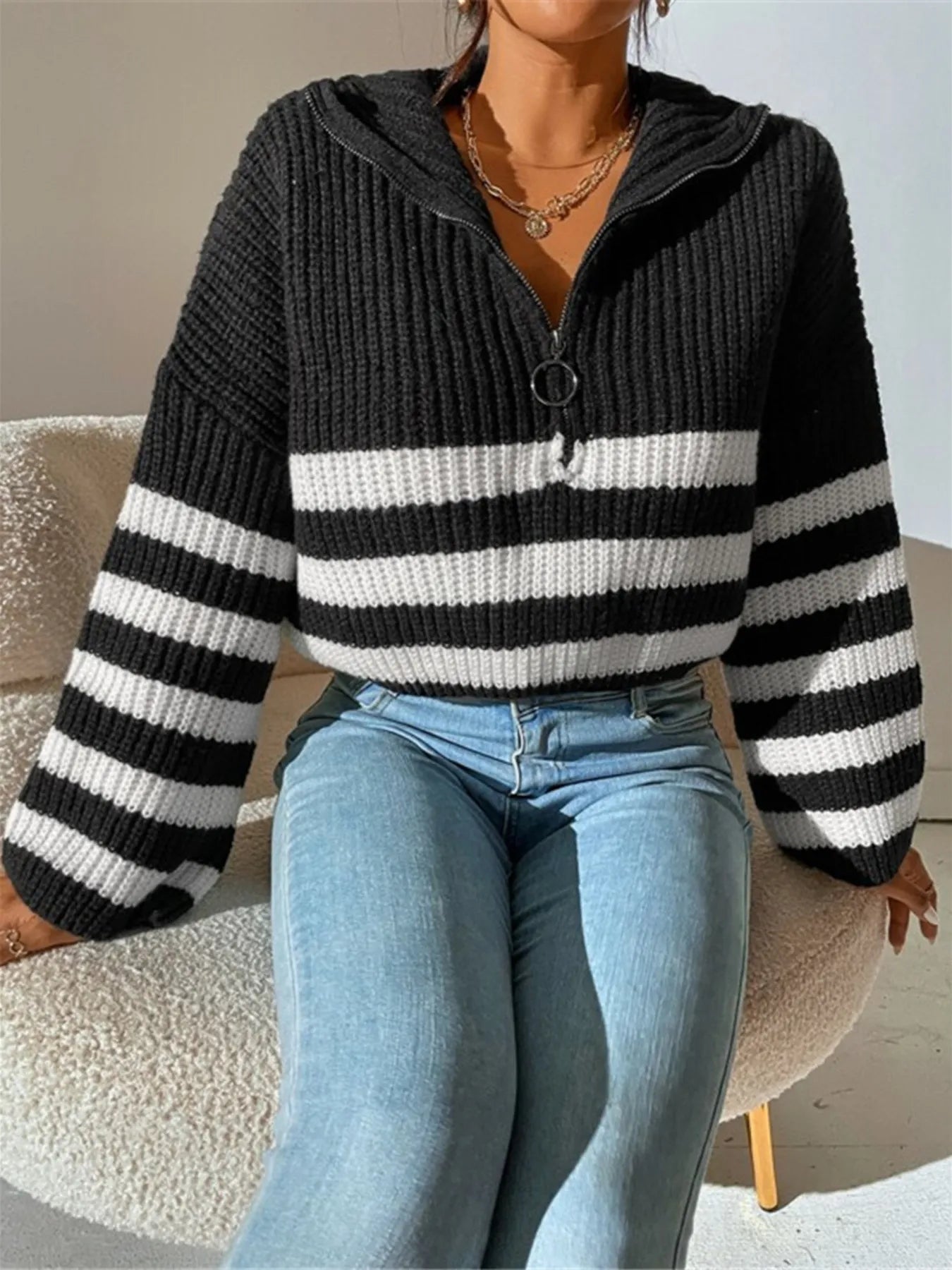 Black cropped half-zip knit sweater with white stripes and ribbed trim at neckline