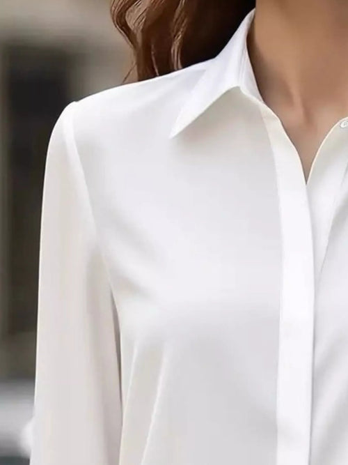White button-down long sleeve shirt, pointed collar and single button at neckline