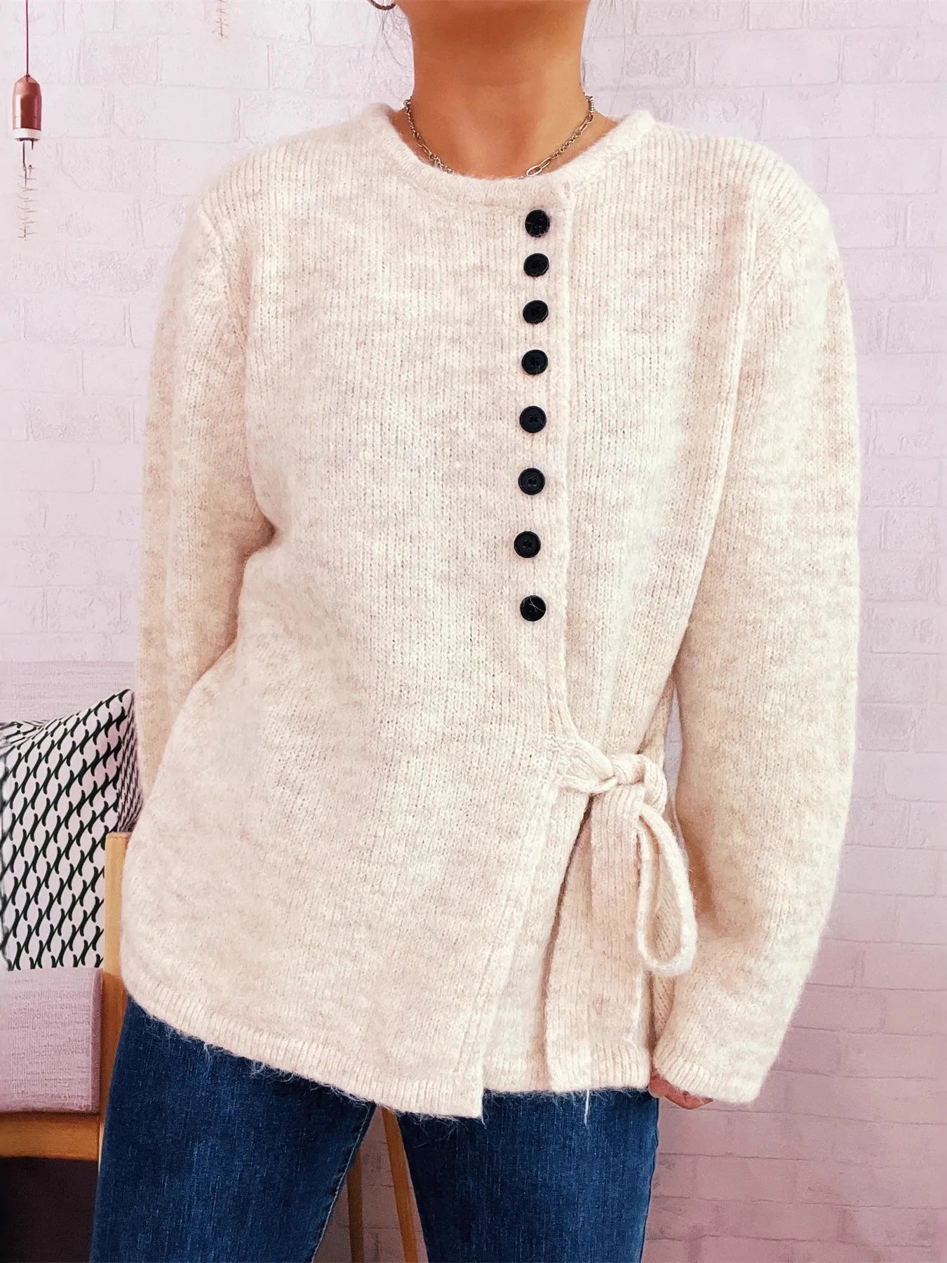 Apricot button-front side-tie sweater with long sleeves and center black button row