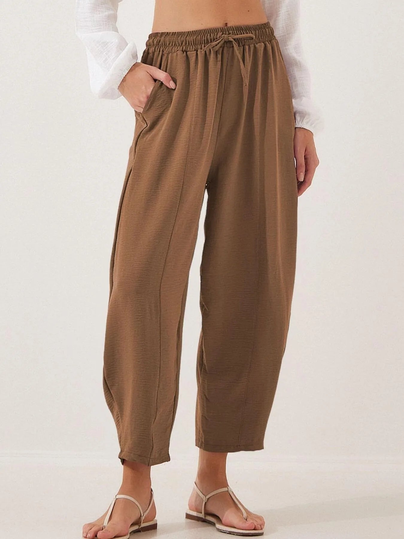 Brown cropped wide-leg drawstring pants with elastic waistband and relaxed fit
