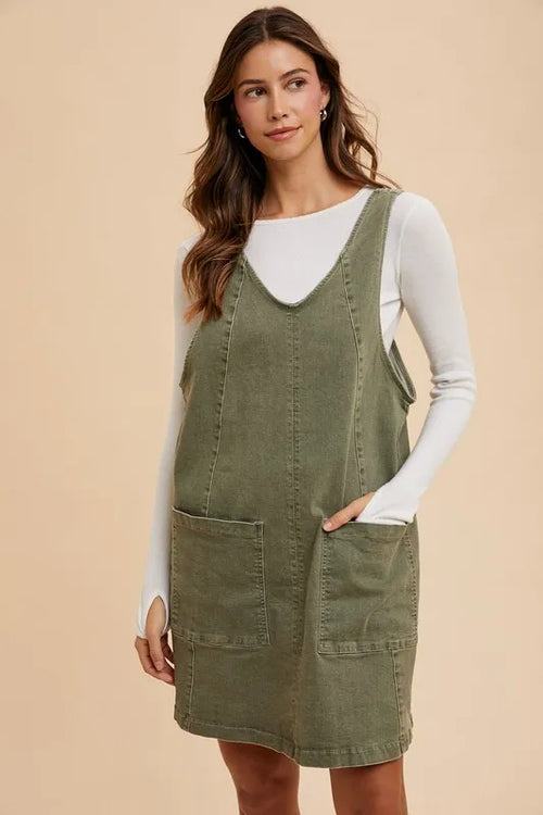 Army green denim overall dress with V-neck, adjustable straps, and two front pockets
