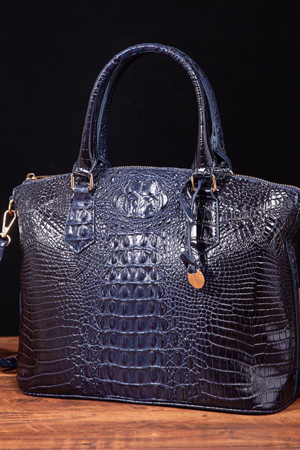 Vegan leather handbag in dark blue with top handles, embossed crocodile texture, and shoulder strap