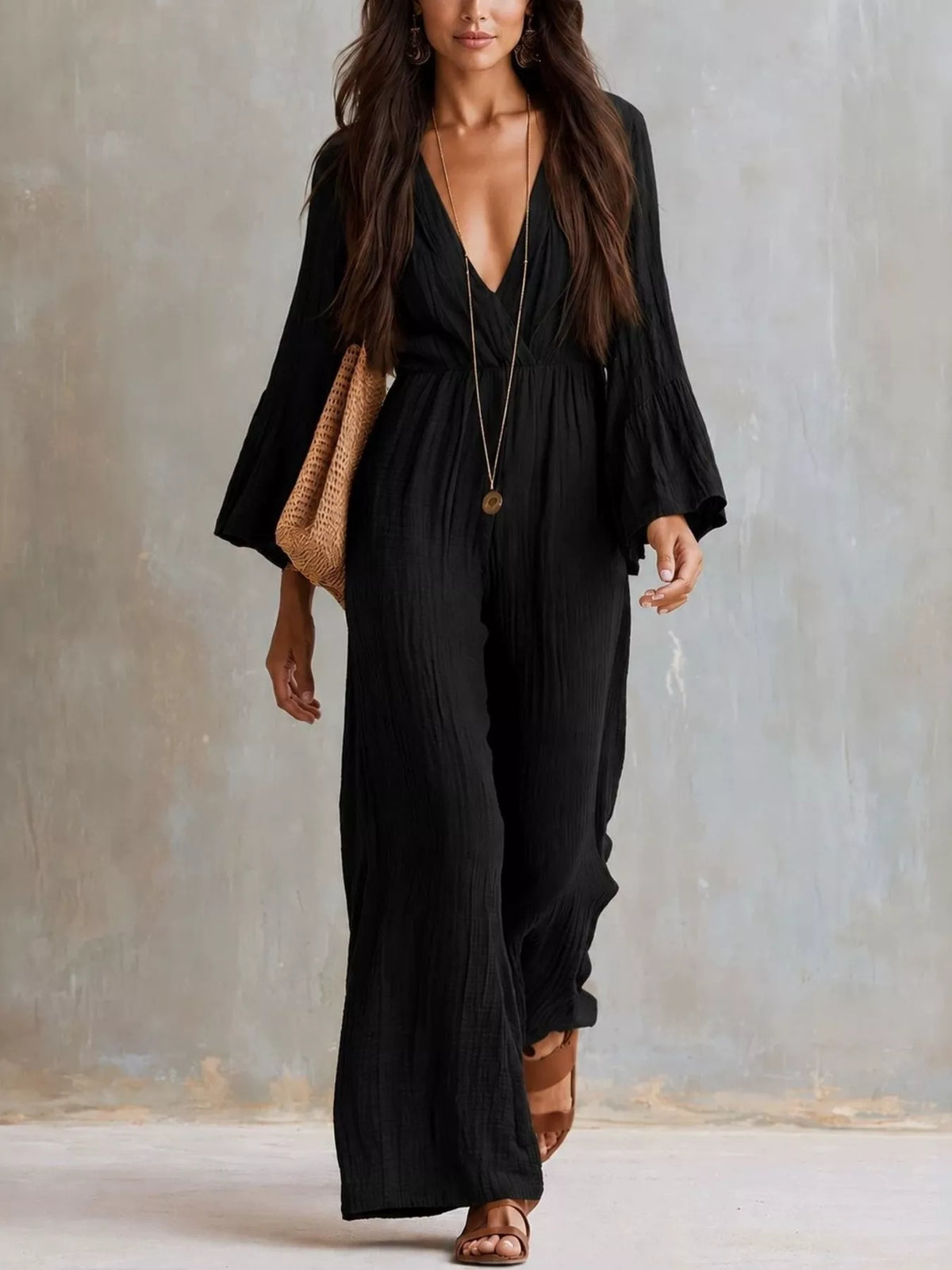 Black textured flare-sleeve jumpsuit with deep V-neck and wide-leg drape