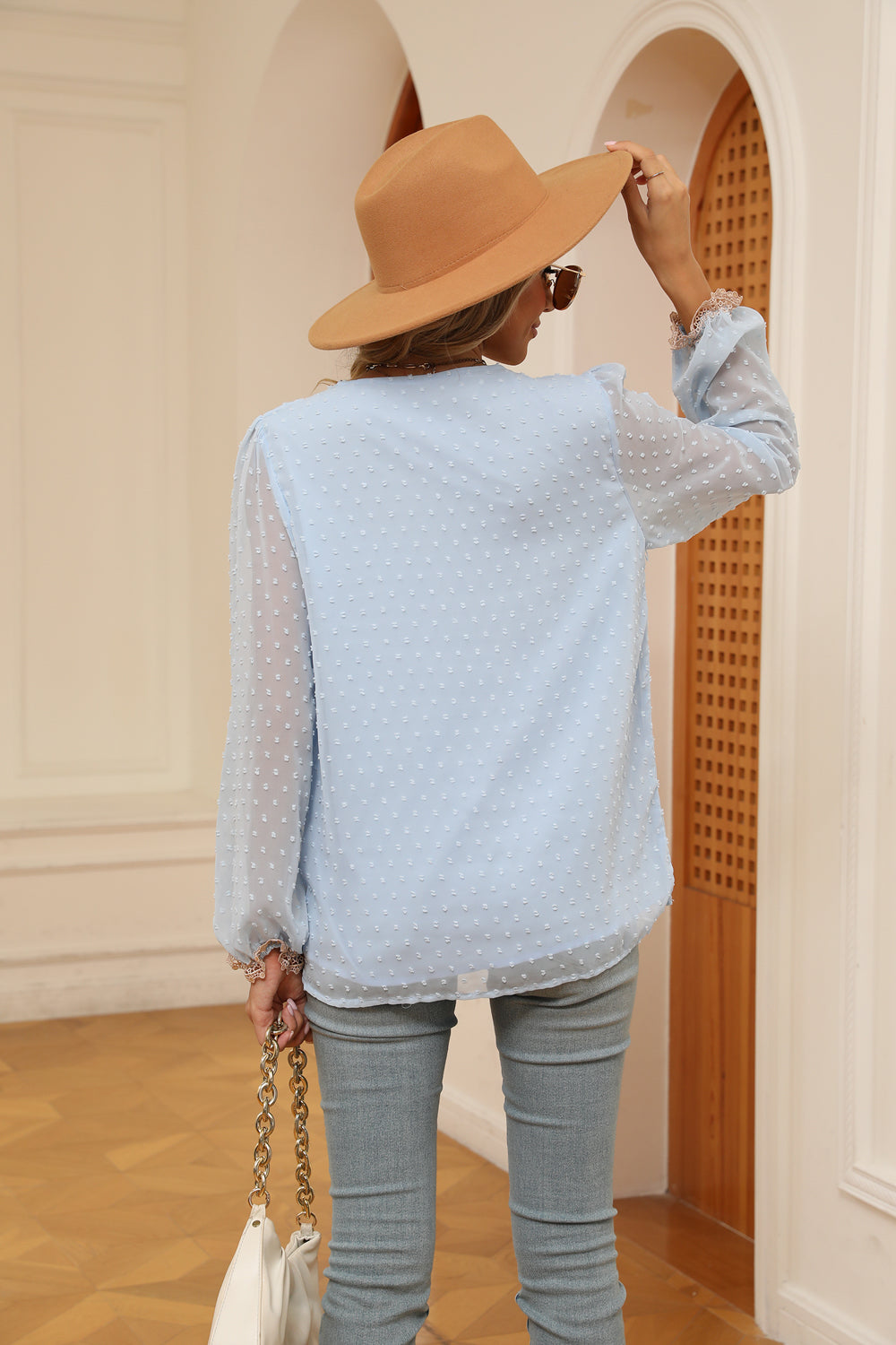Misty blue swiss-dot V-neck blouse with cream trim and buttoned cuffs, back