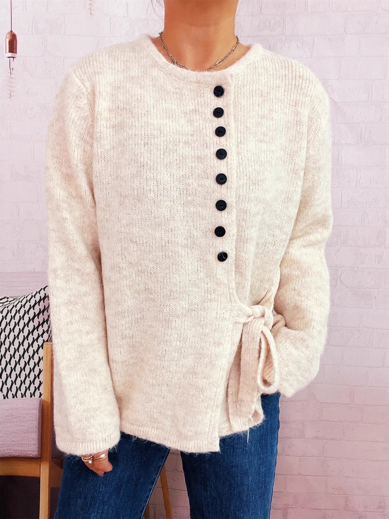 Apricot button-front side-tie sweater with long sleeves and black button placket