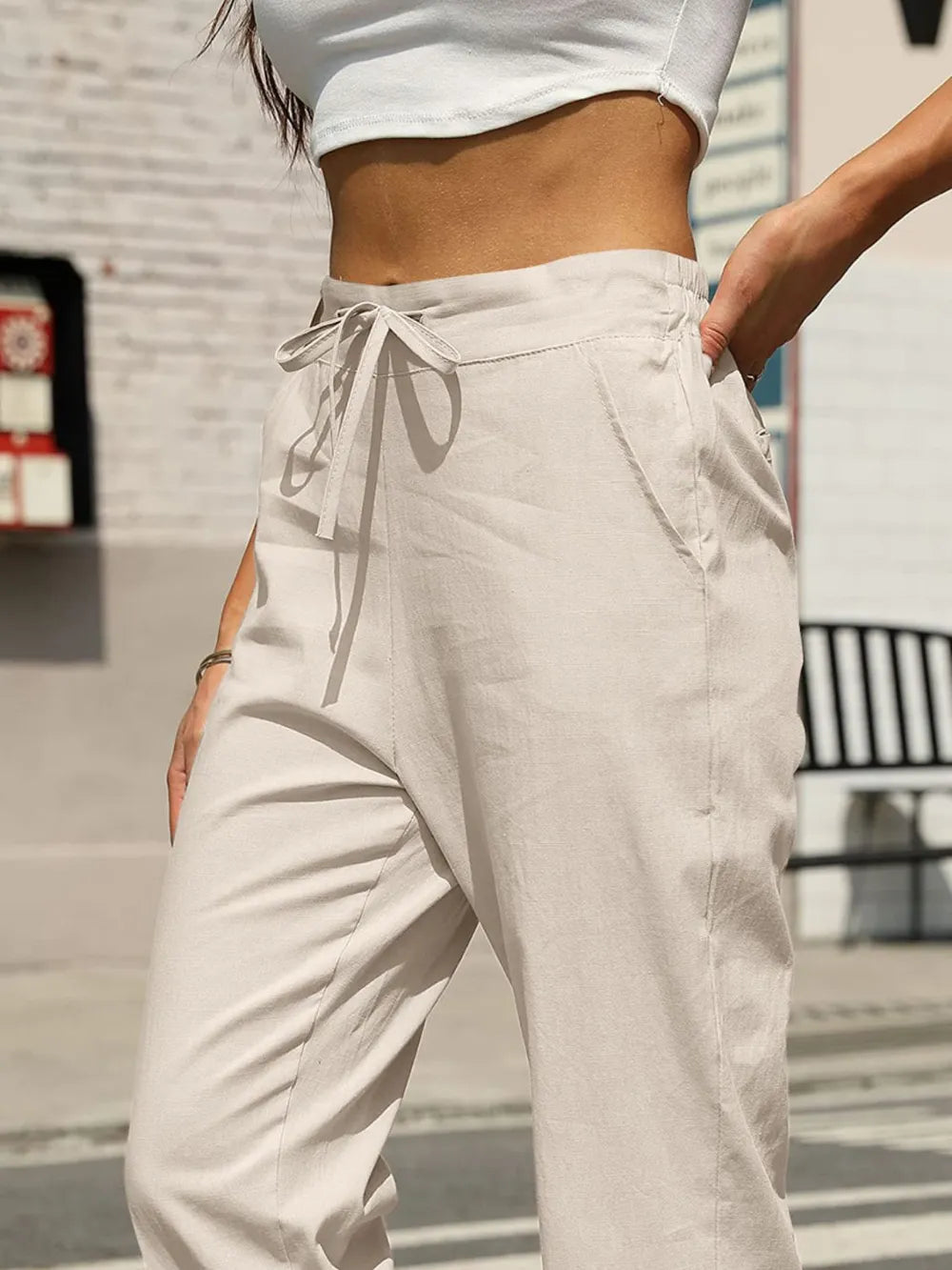 Light beige elastic waist tapered pants with drawstring bow at the front