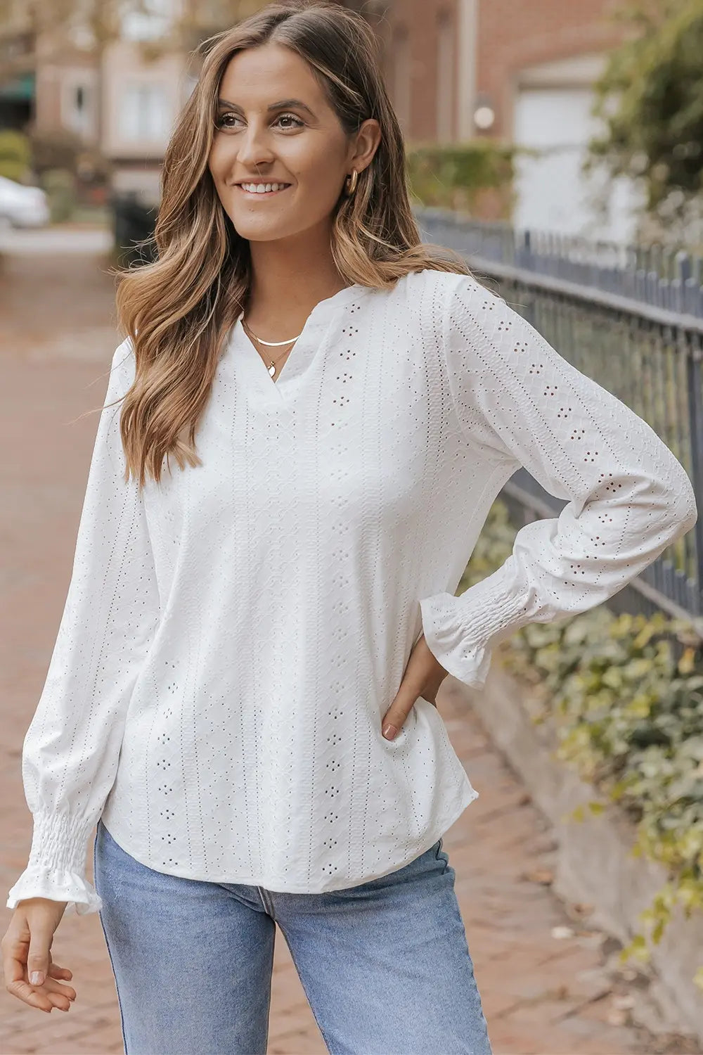 White openwork notched blouse with long sleeves and eyelet-style lace pattern