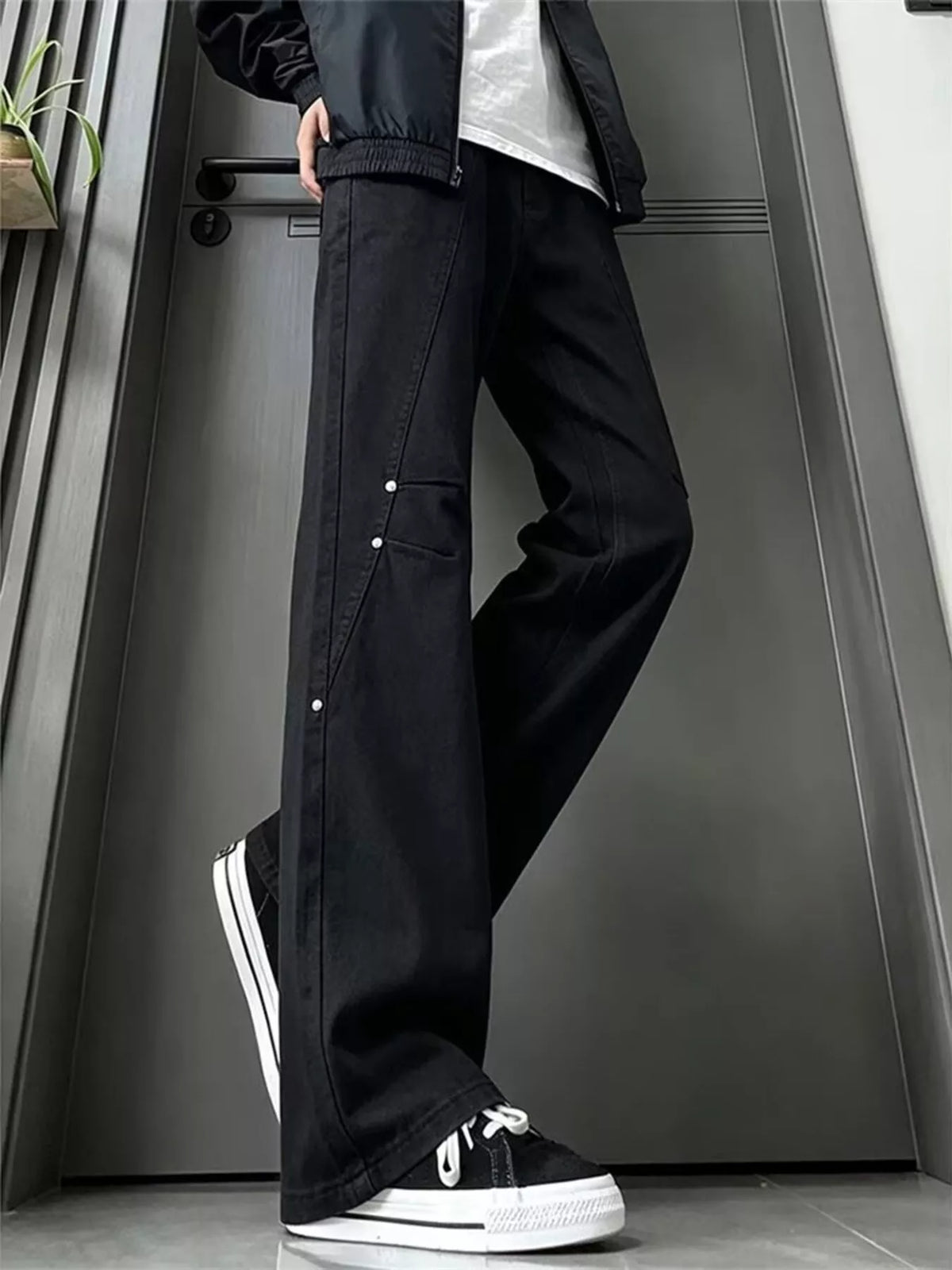 Black wide-leg denim jeans with buttoned leg panels and relaxed waist