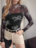 Printed mock neck long sleeve mesh T-shirt in black with white bow pattern.