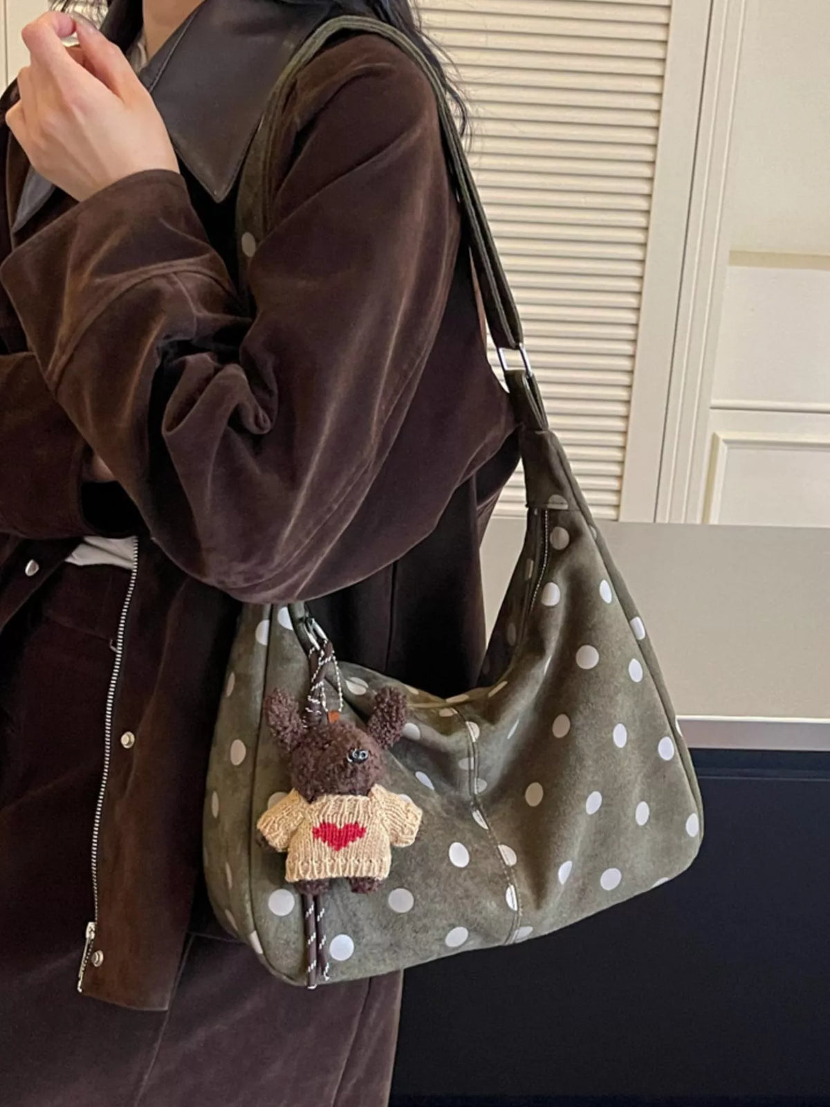 Green suede polka-dot shoulder bag with teddy charm, adjustable strap, and front pocket