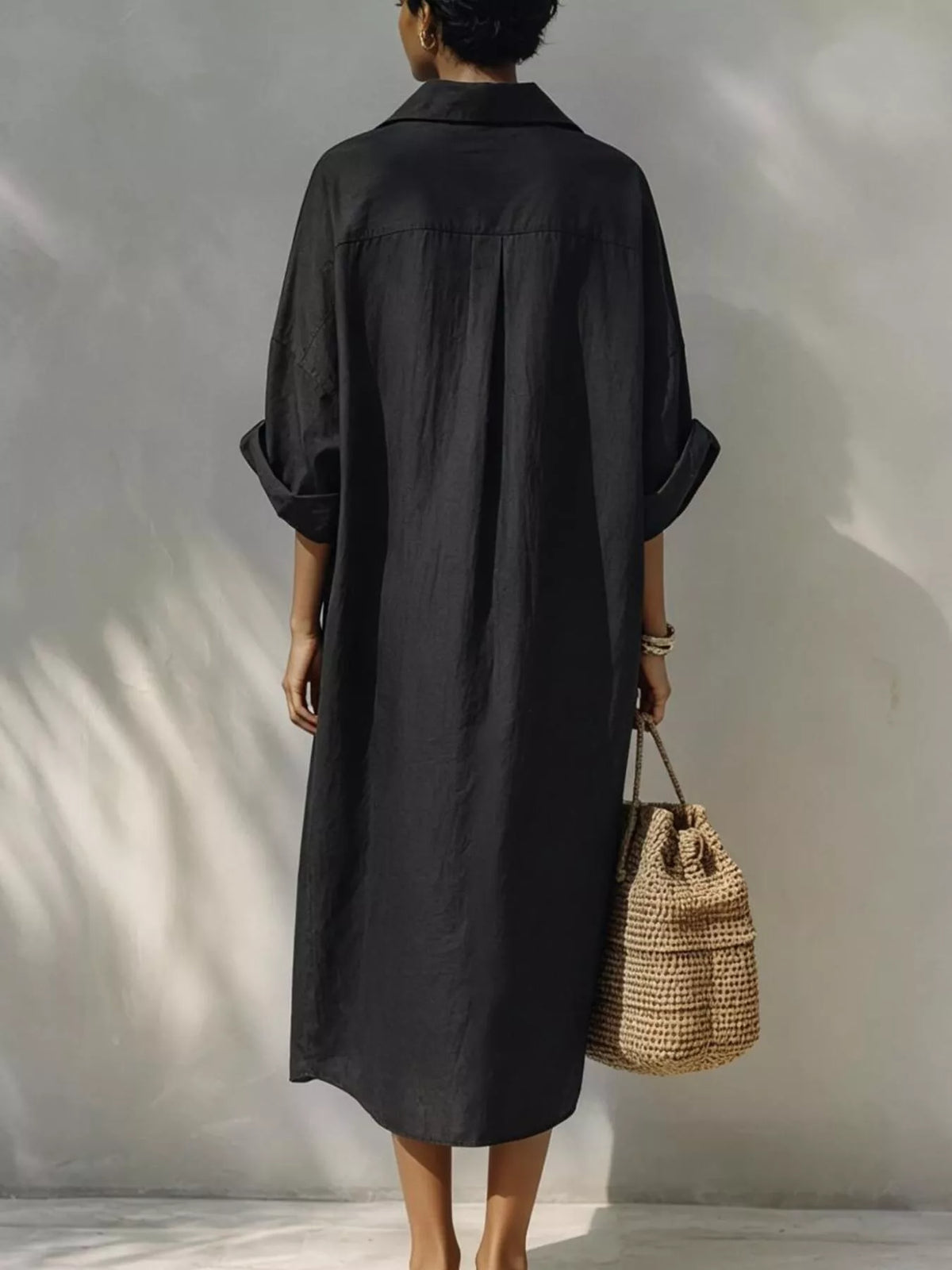 Black button-front shirt dress, back view with draped shoulders and midi length