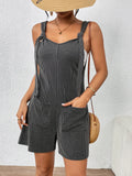 Black pinstripe knotted-strap romper with front pockets and short relaxed legs