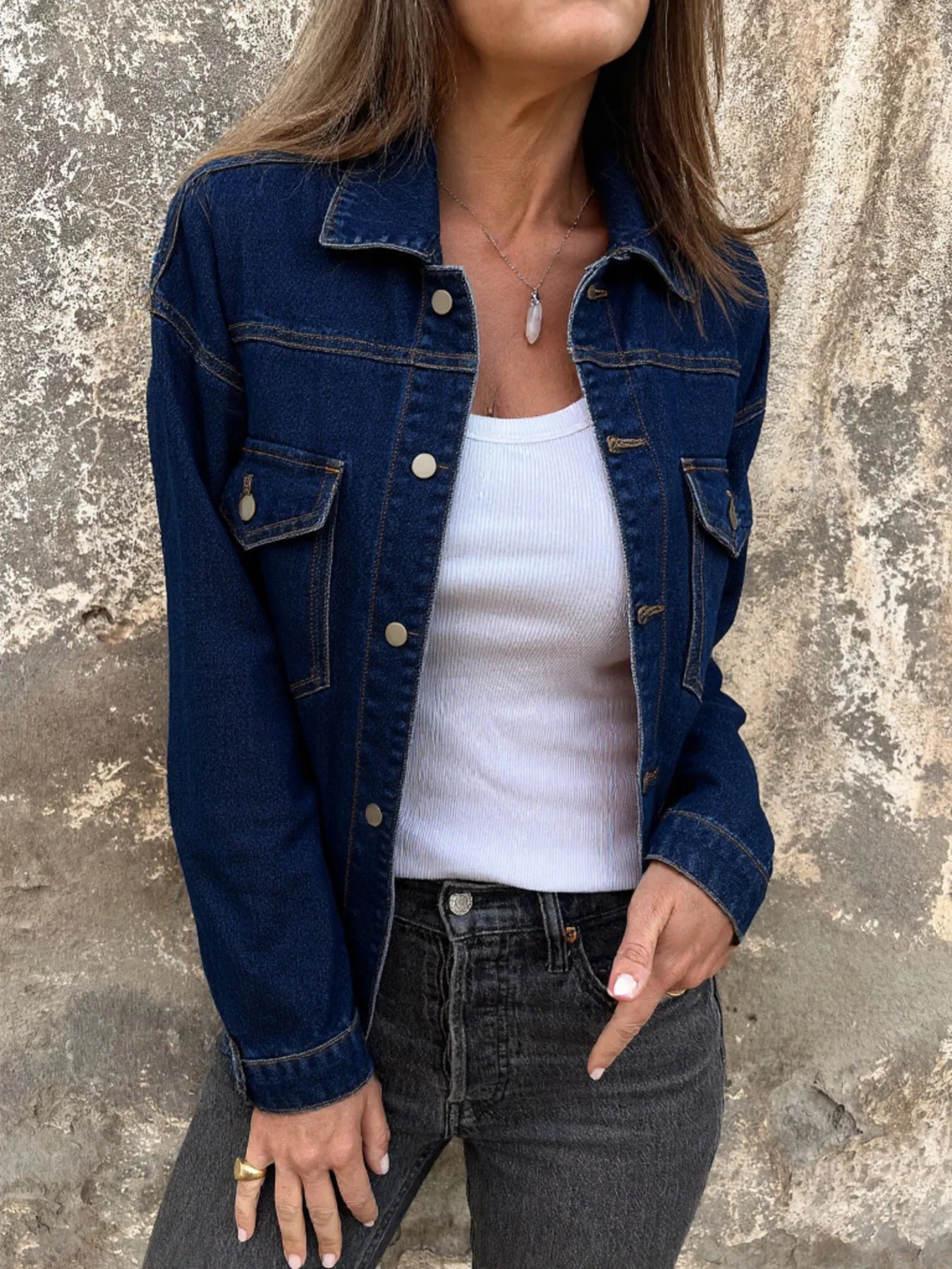 Blue denim jacket with button front, pointed collar, and chest flap pockets