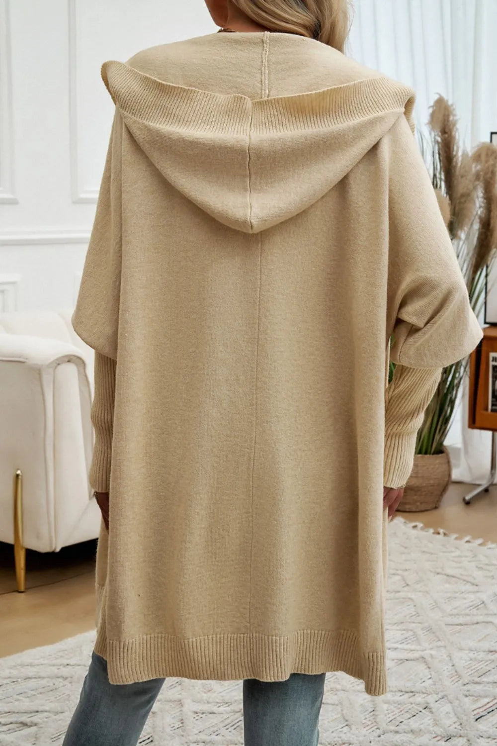 Tan hooded long cardigan, shown from back with draped hood and button front.