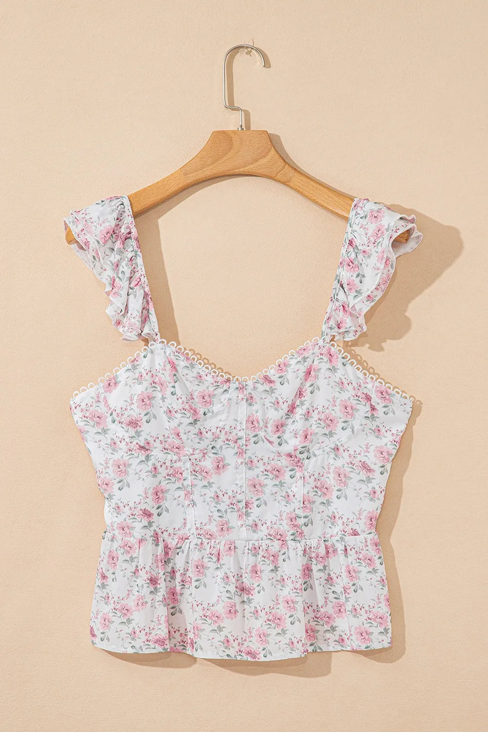 Floral peplum tank top on hanger with blush pink floral print and ruffled shoulders