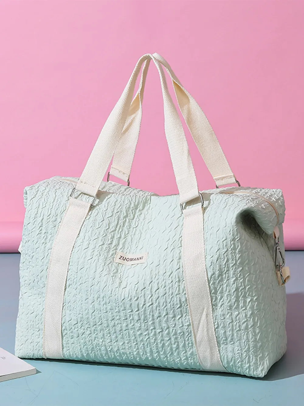 Light mint textured duffle travel bag with beige straps and side zipper