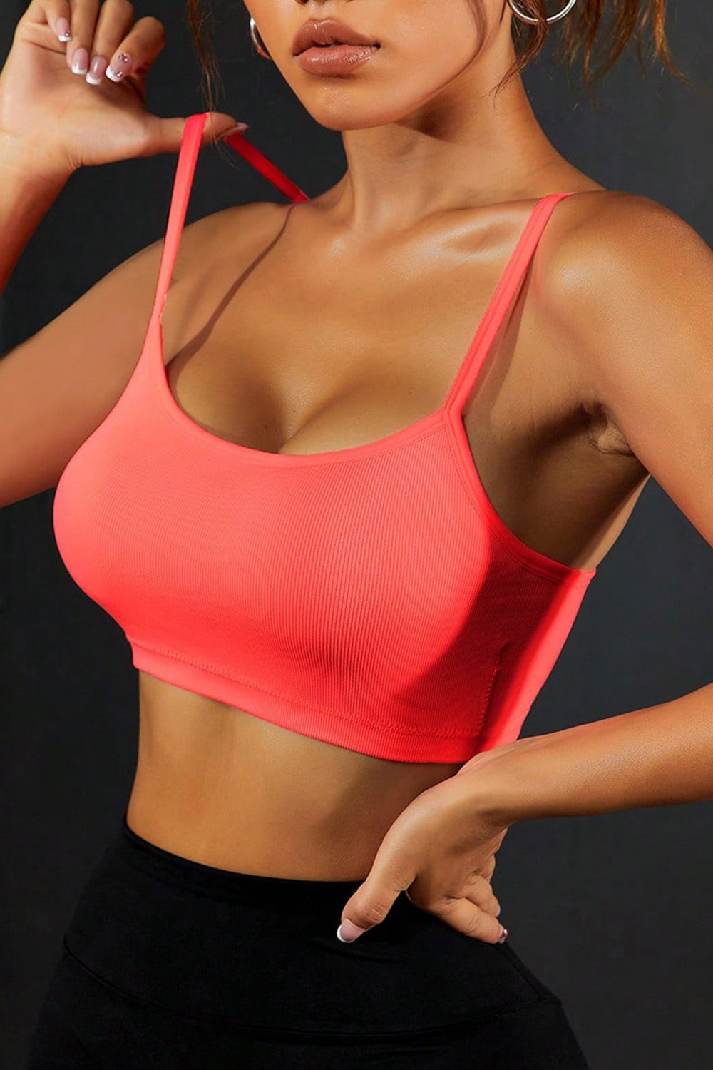 Coral sports cami with scoop front, thin straps, and ribbed fabric.
