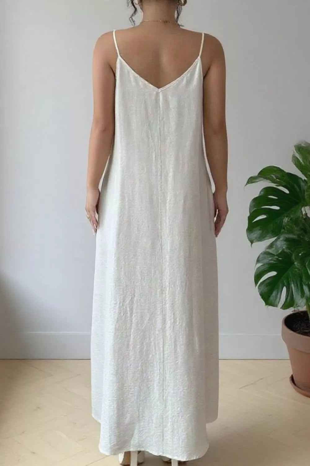 White spaghetti-strap maxi dress with open back and subtle textured fabric