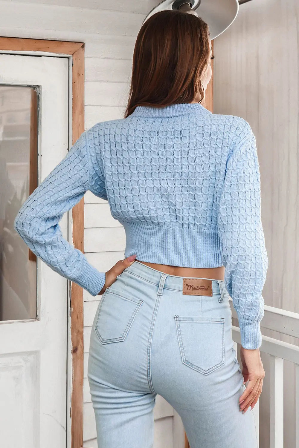 Light blue cropped knit sweater, round neck, long sleeves; back view