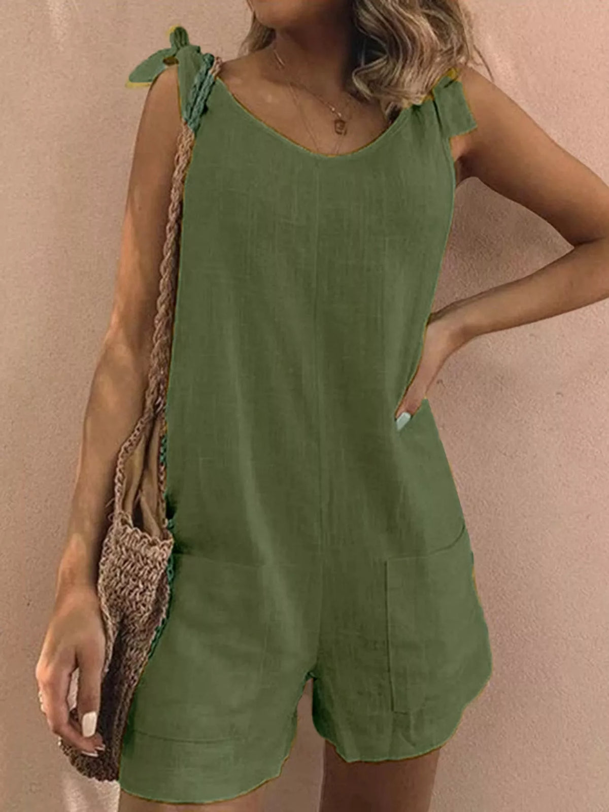 Green tie-shoulder bow romper with front pockets and short, mid-length jumpsuit legs