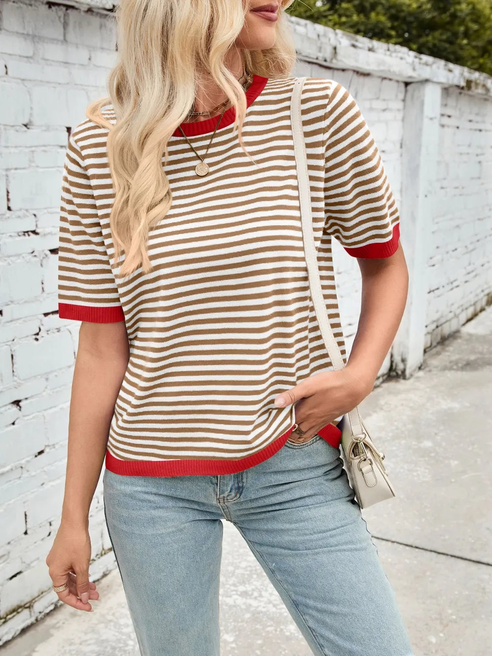 Black-and-white striped knit top with red contrast round neck and ribbed sleeve cuffs