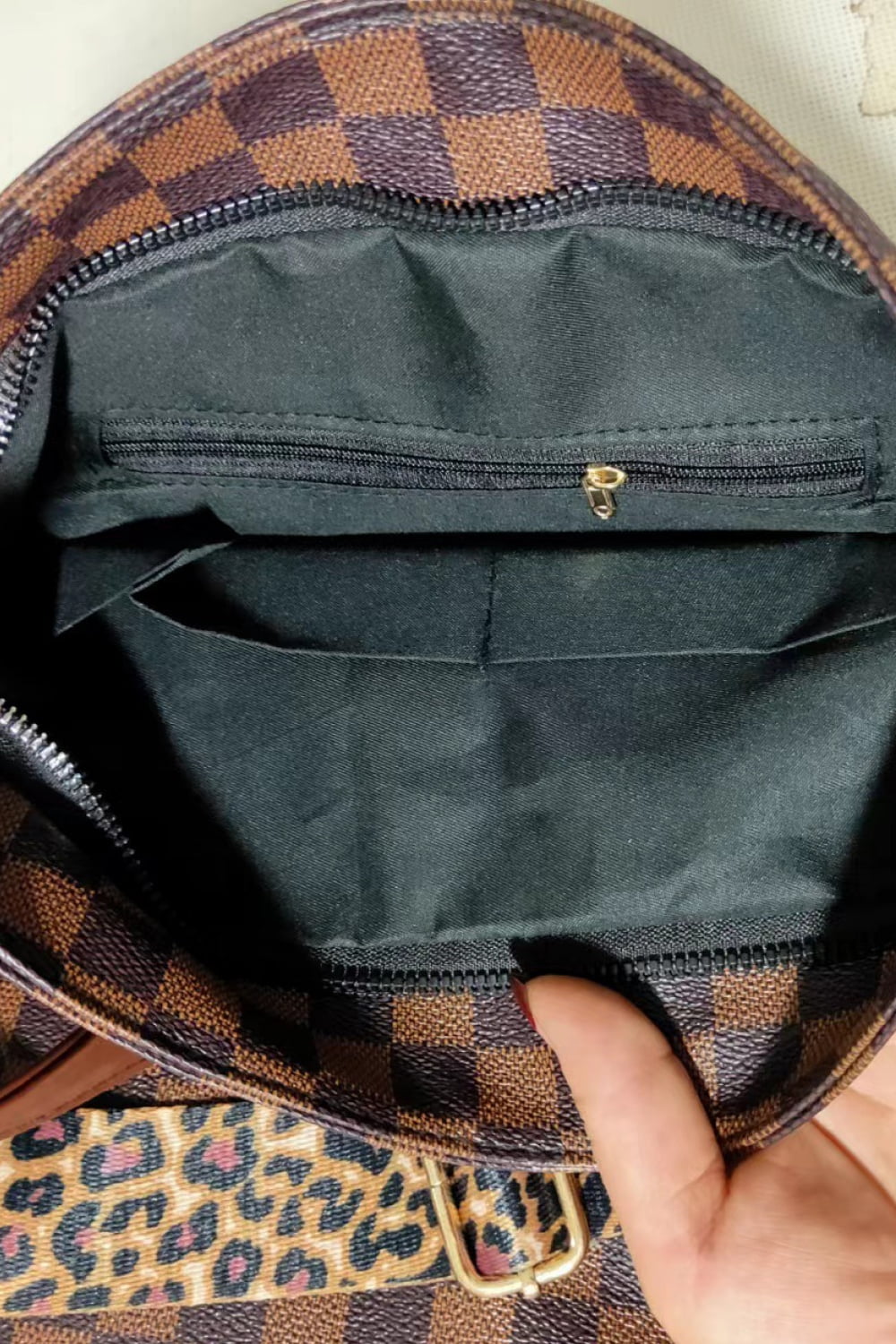 Brown check PU leather zip-top bag interior with fabric lining and gold zipper pull