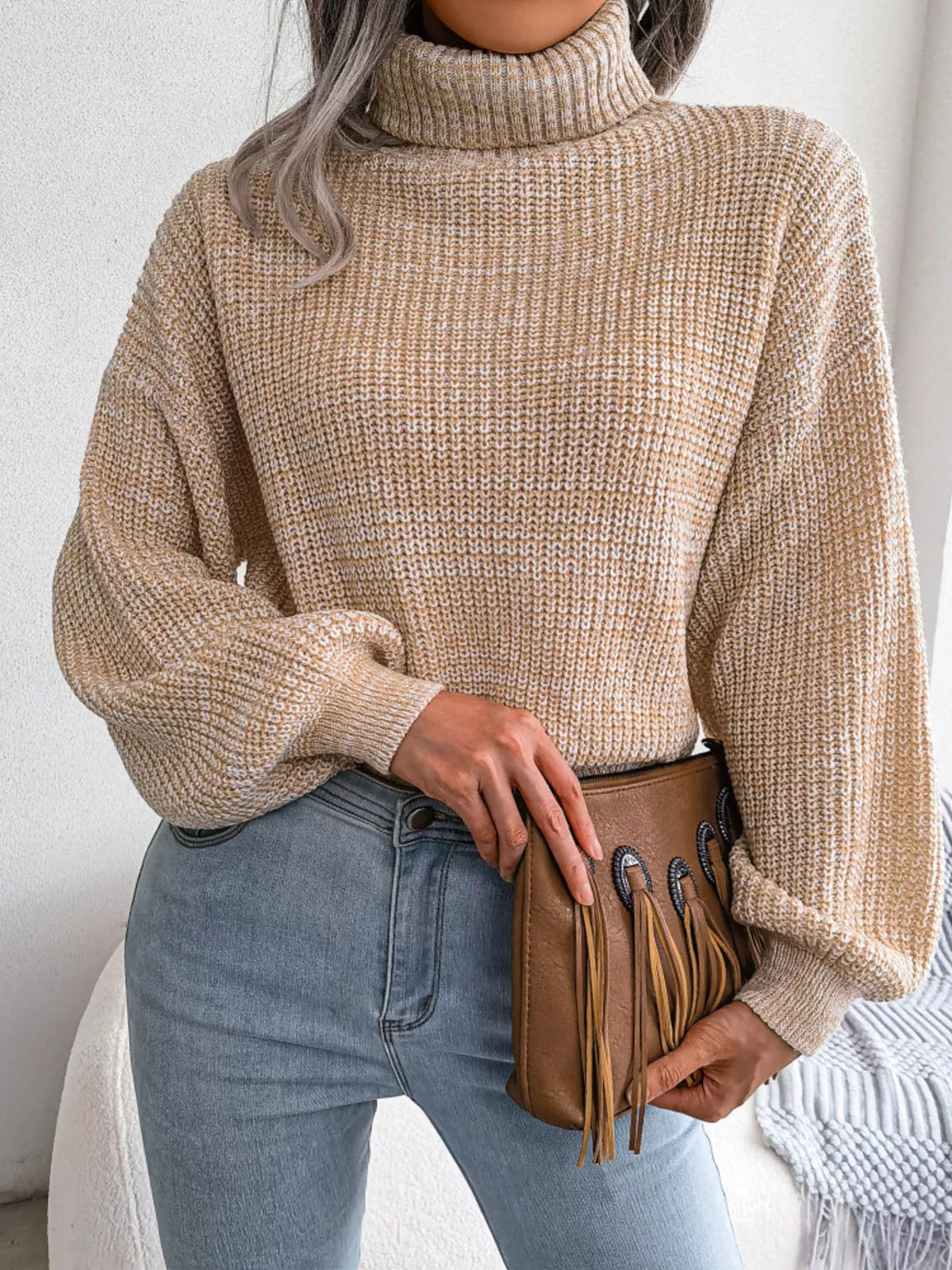 Beige waffle knit turtleneck sweater with chunky texture and relaxed drop shoulders.