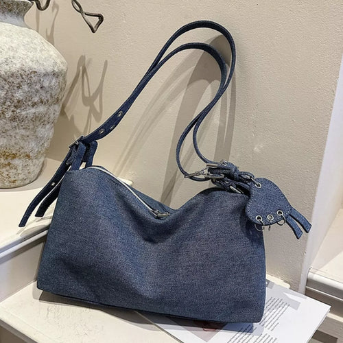 Dark blue denim crossbody bag with adjustable strap and knotted drawstring front