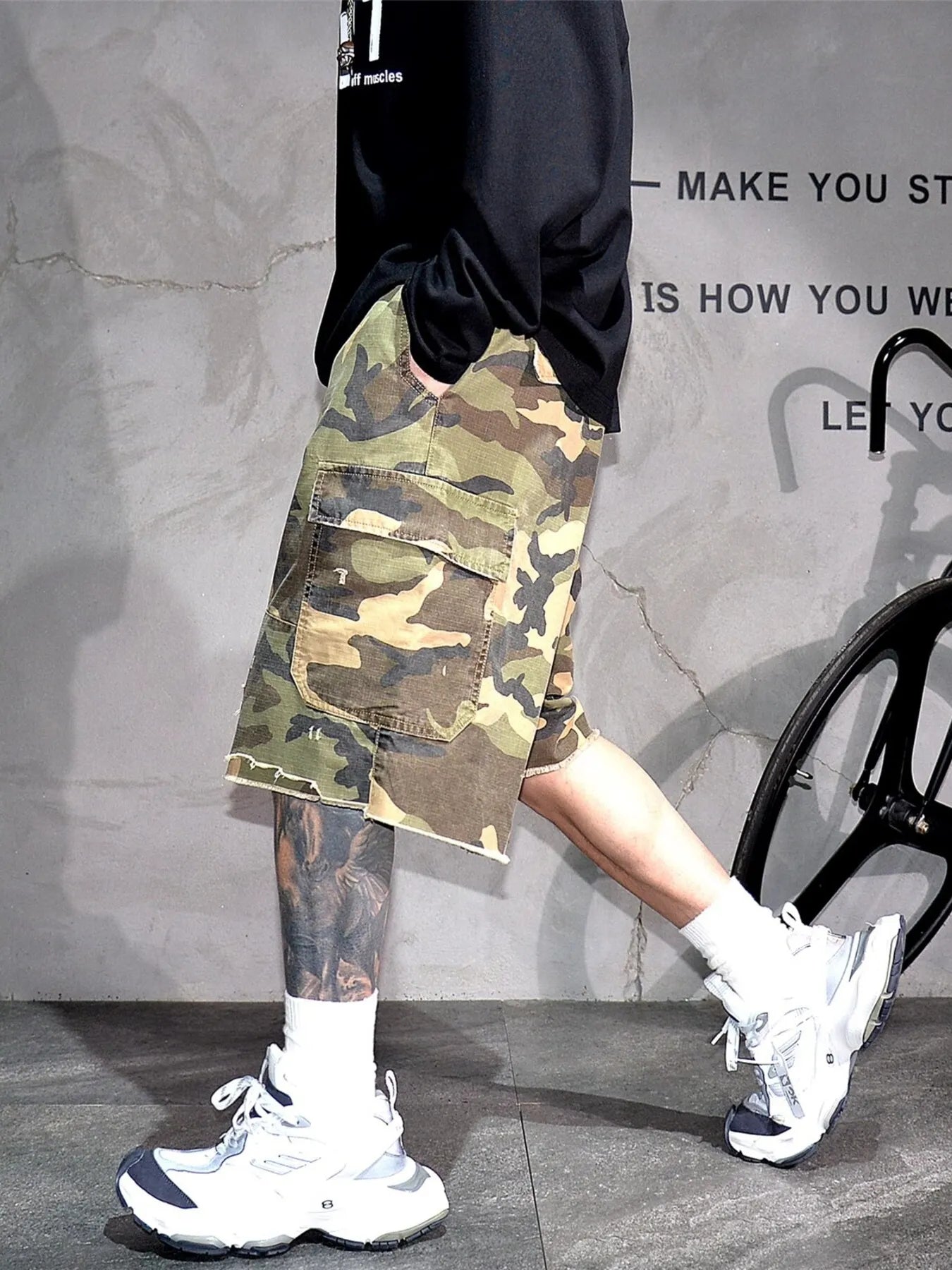 Light green camo cargo shorts with side flap pockets and belt loops