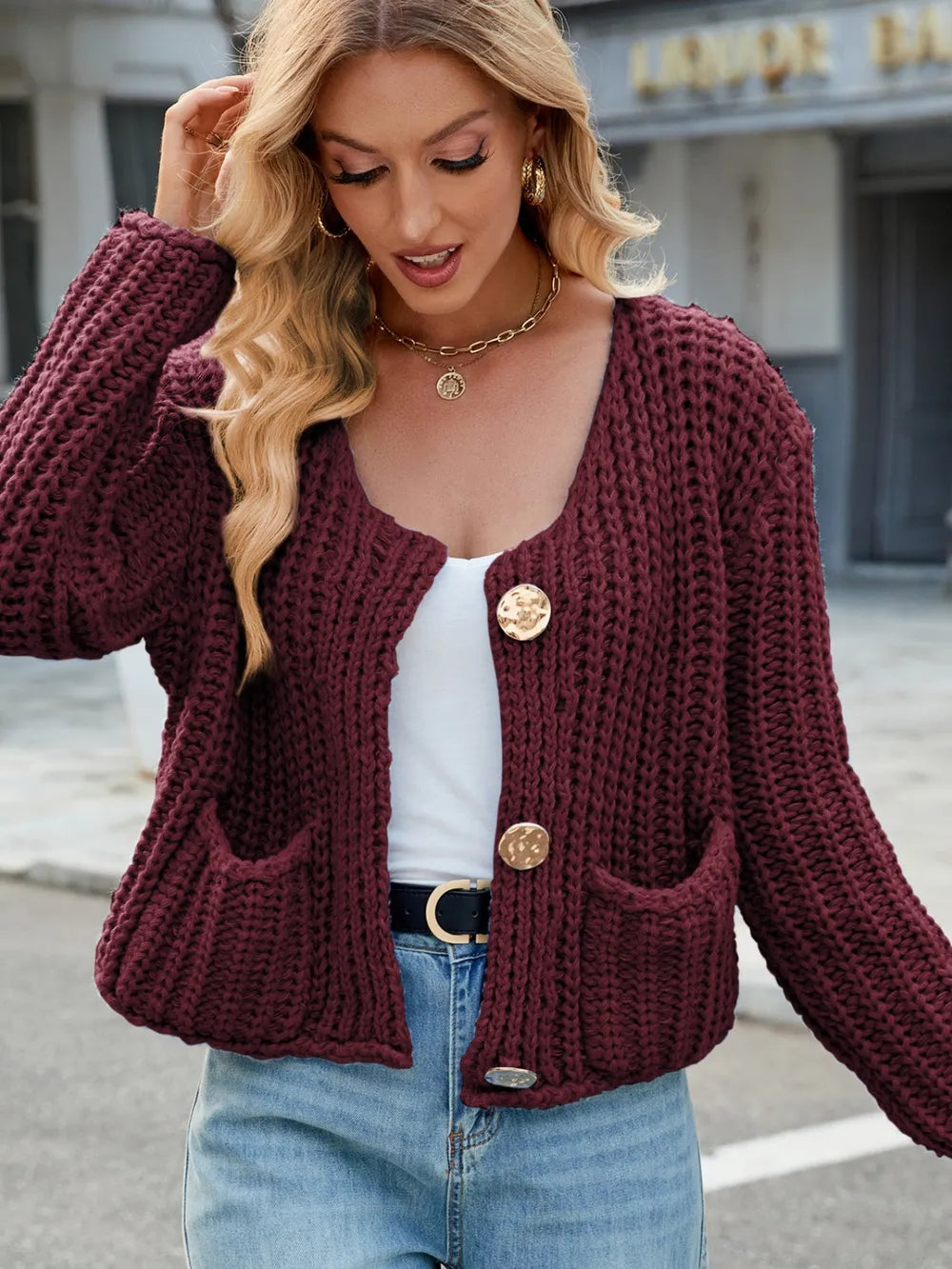Burgundy round-neck knit cardigan with gold buttons and patch pockets, long sleeves