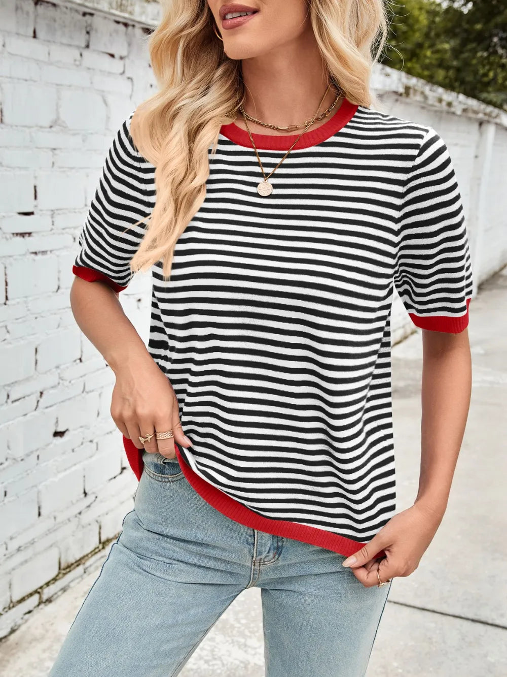 Black-and-white striped knit top with red contrast round neck and rib trim
