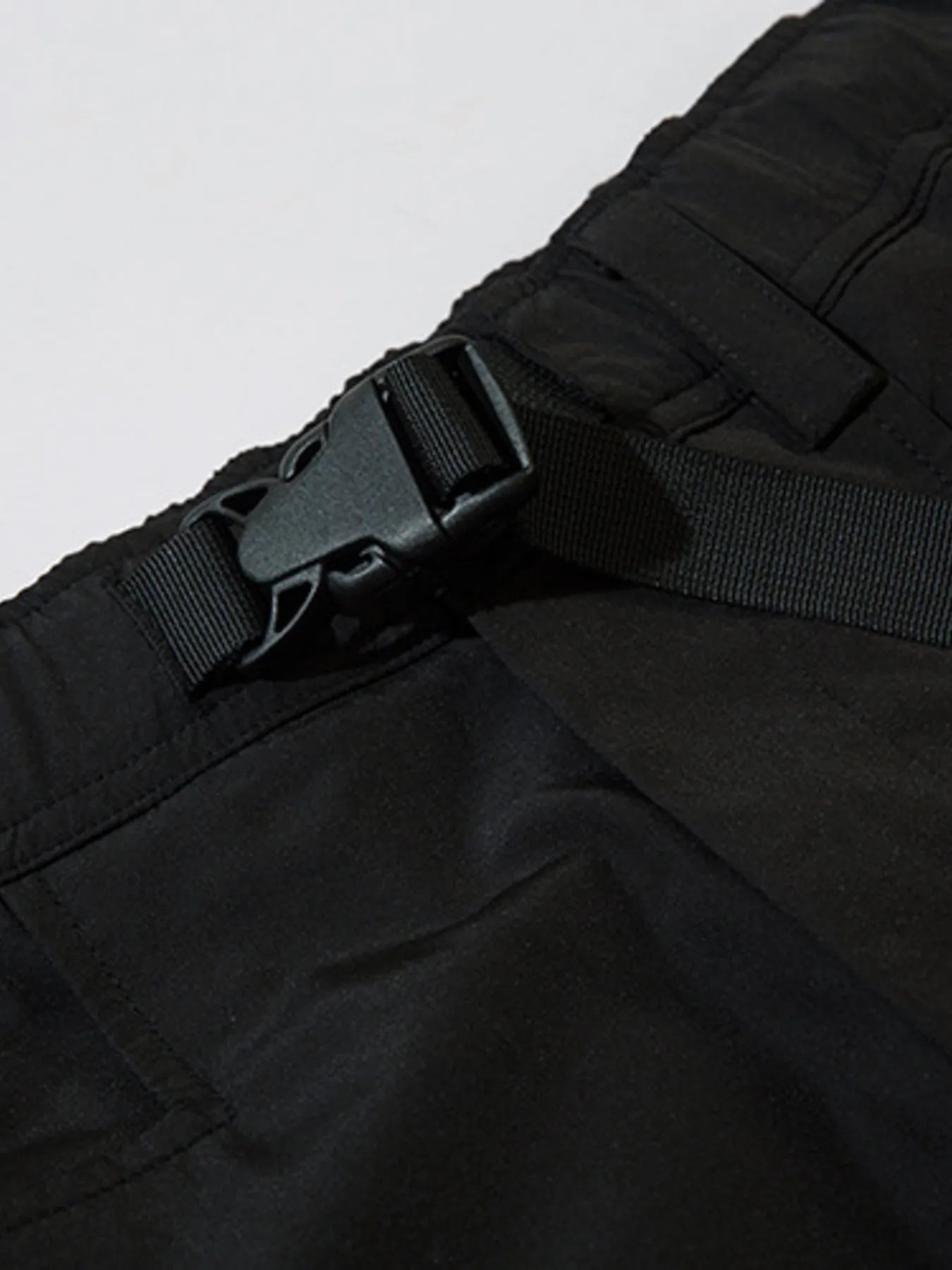 Black cargo joggers close-up of waistband strap and adjustable buckle