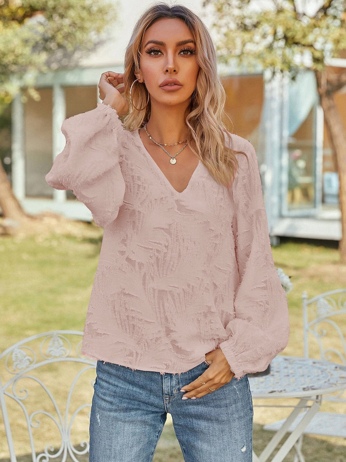 Blush pink V-neck long sleeve blouse with ruffled puff sleeves, textured front
