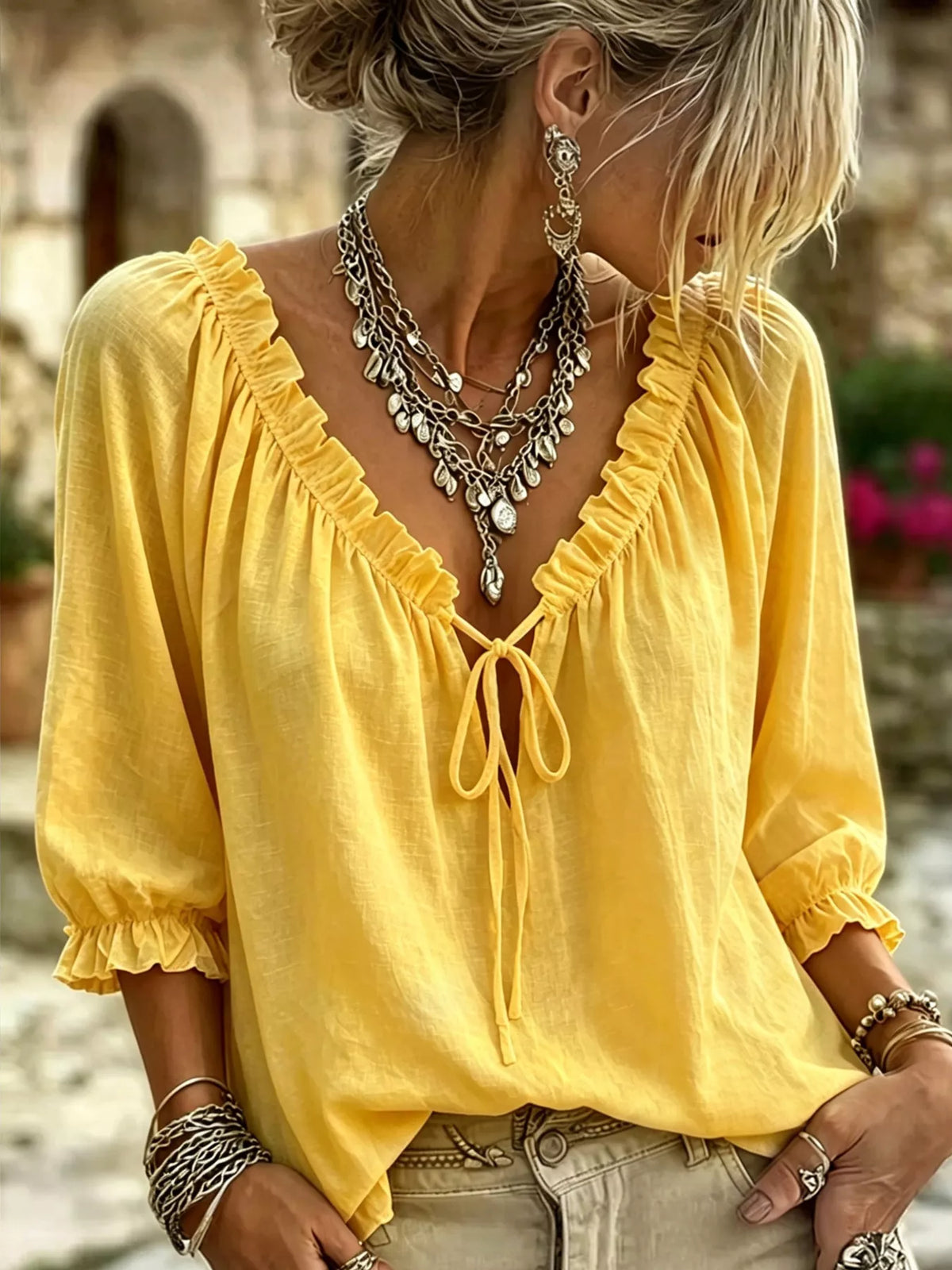 Yellow tie-neck blouse with frilled V neckline and three-quarter puff sleeves