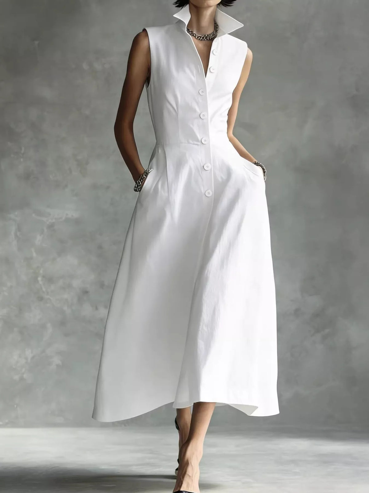 White sleeveless midi button shirt dress with pointed collar and centered front buttons.