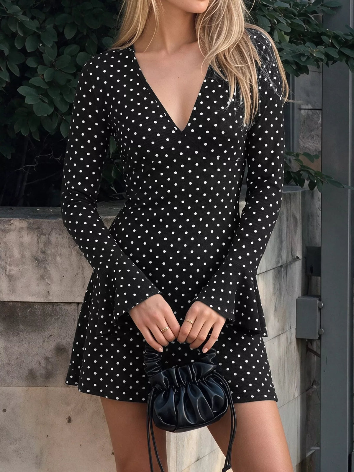 Black polka dot long-sleeve mini dress with V-neck and flared ruffle hem