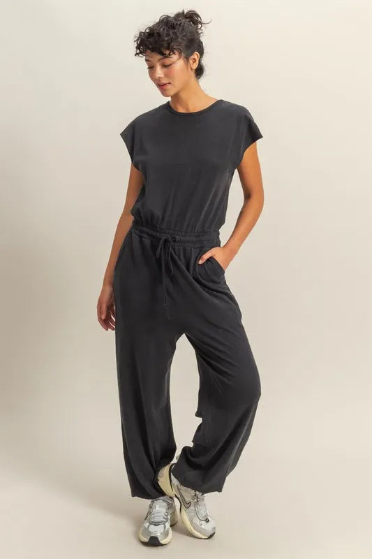Black cap-sleeve jumpsuit with round neck, elastic drawstring waist, wide legs.