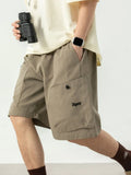 Khaki drawstring shorts with side pockets, elastic waist and button detail