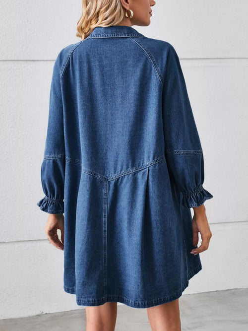 Back view of navy denim button-front dress with ruffle cuffs and yoke stitching