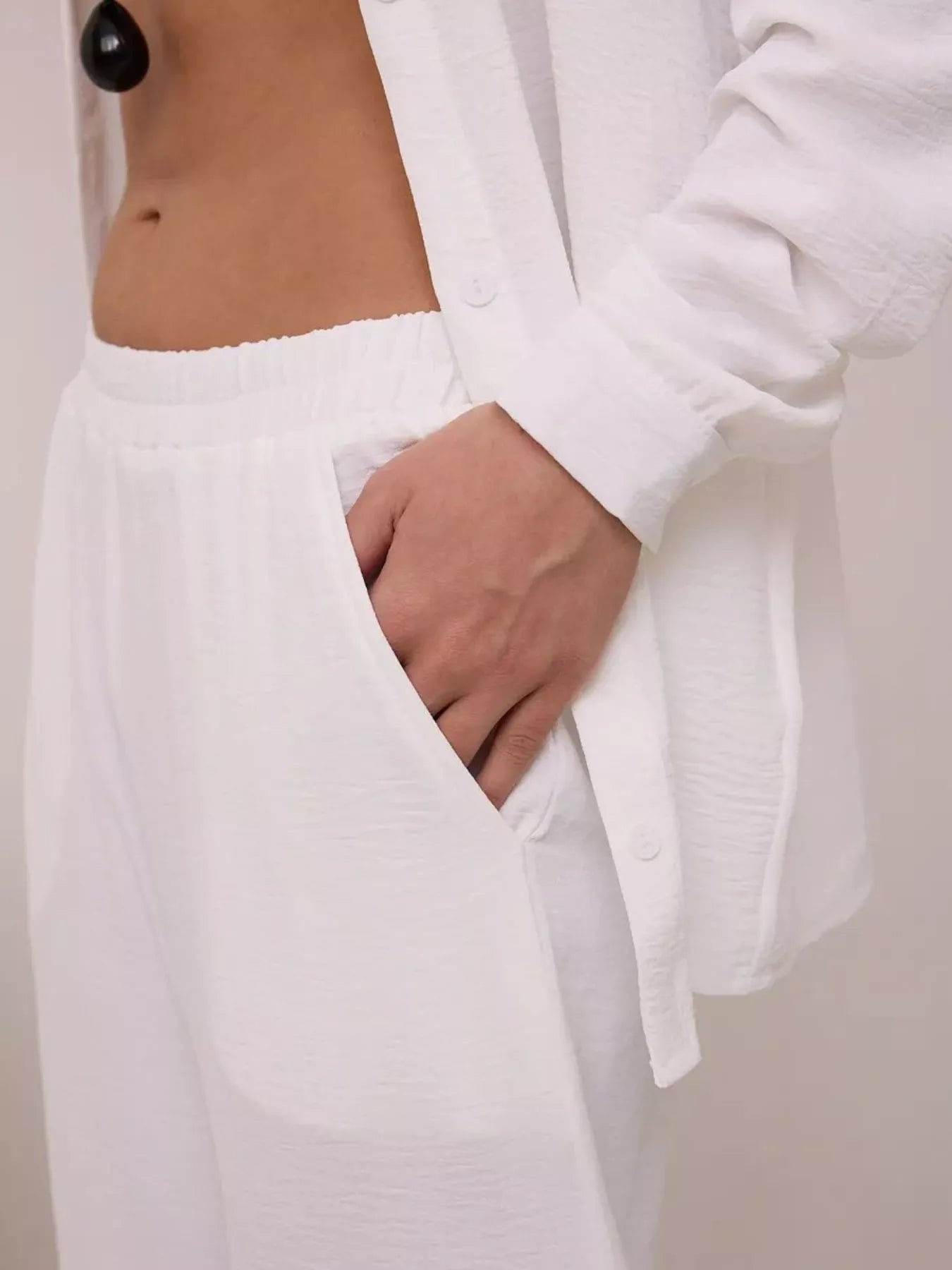 White wide-leg pants with relaxed shirt, close-up of waistband and shirt hem