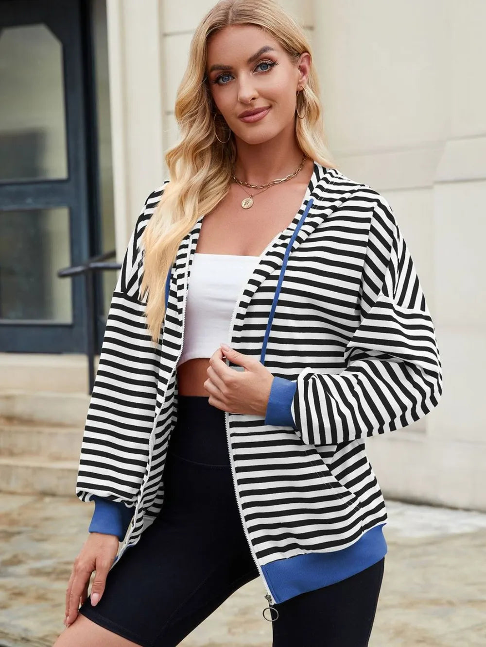 Striped zip-up hoodie with drawstring, black and white stripes, blue hem trim, front zip