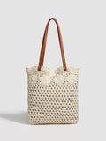 Crochet knit tote handbag with top handles, cream body and brown leather straps.