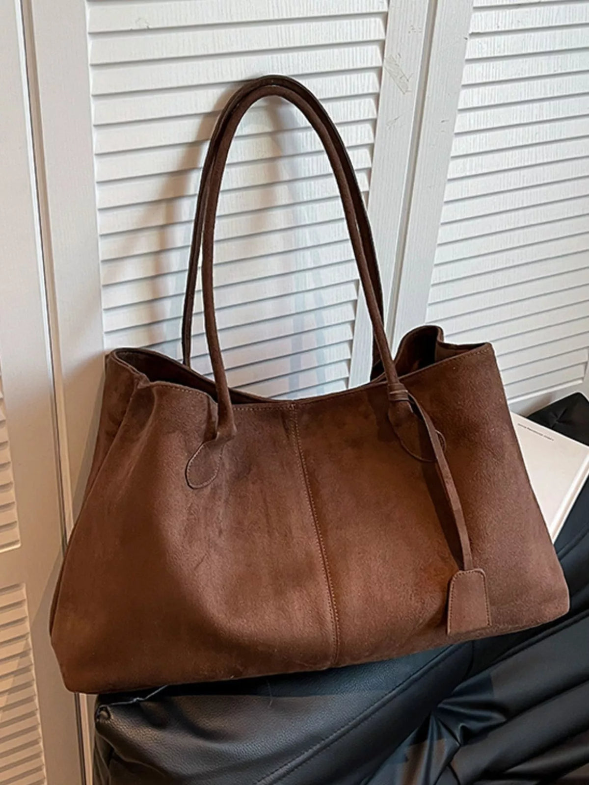Brown suede tote bag with structured base, dual handles, and front side pocket