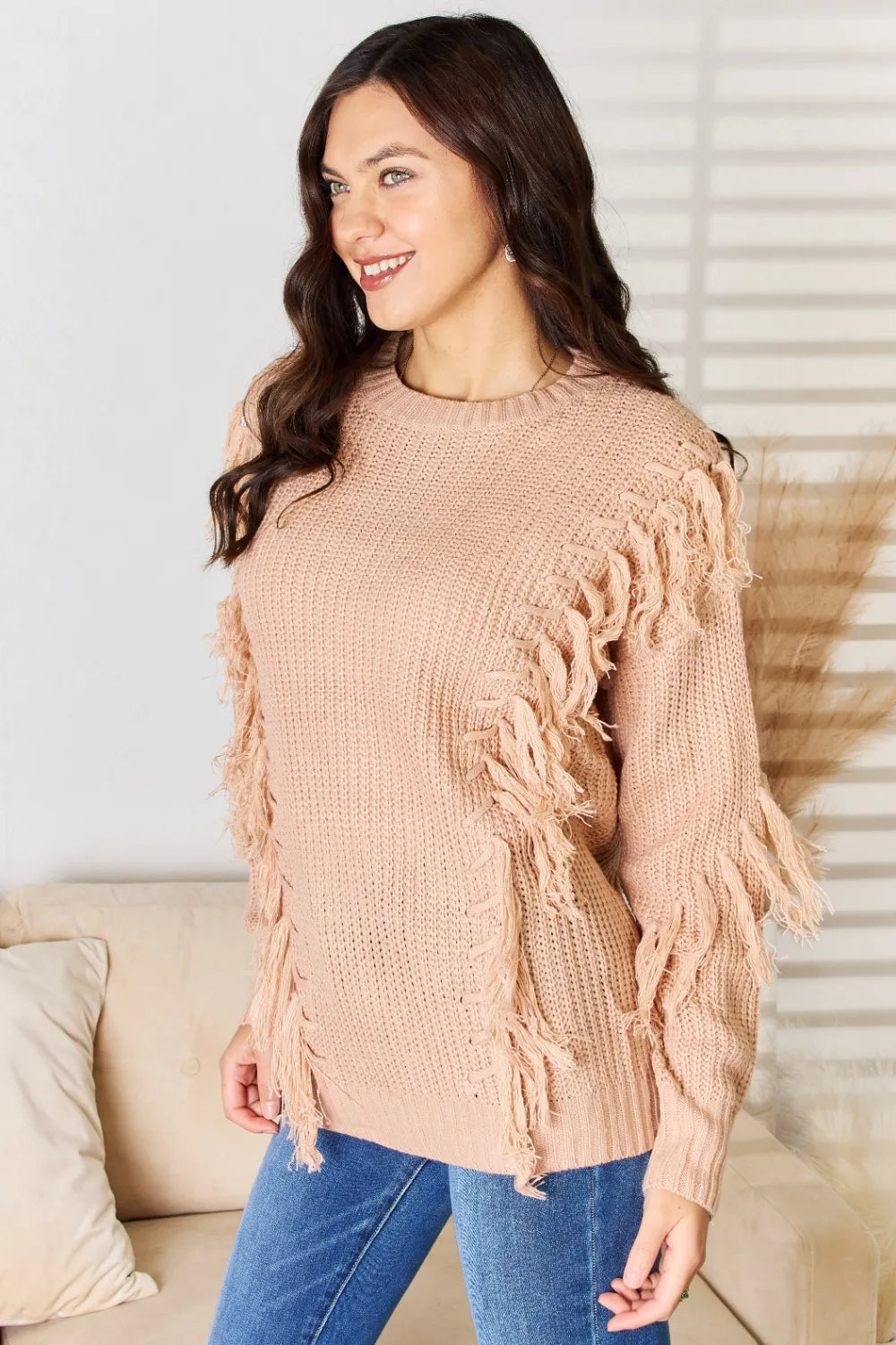 Dusty pink long sleeve sweater with fringe tassels at shoulder and sleeve cuffs