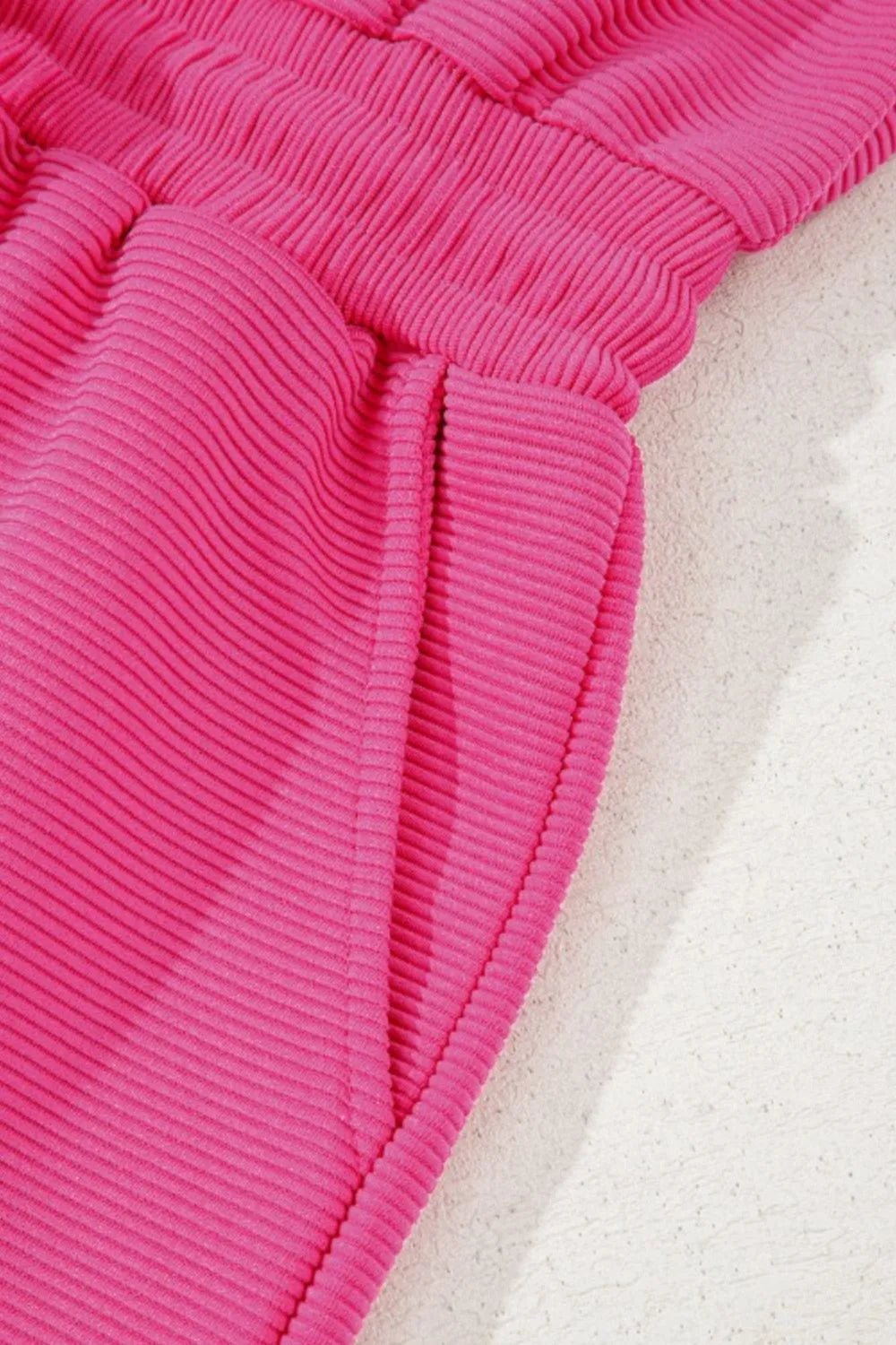 Hot pink textured romper with half-zip front and ribbed short sleeves